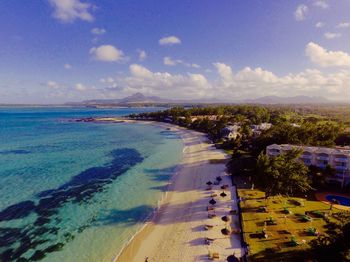 Scenic view of beach against cloudy sky