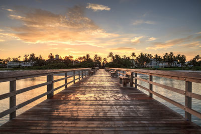 View of bridge over calm sea at sunset