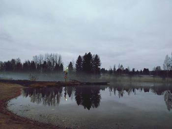 Reflection of trees in lake against sky