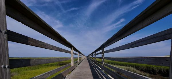 Bridge over road amidst field against sky