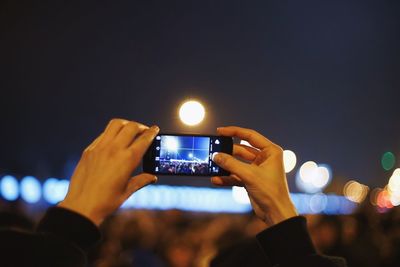 Cropped image of man photographing through smart phone