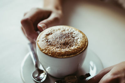 Close-up of hand holding coffee cup