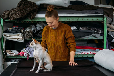 Full length of woman sitting with dog