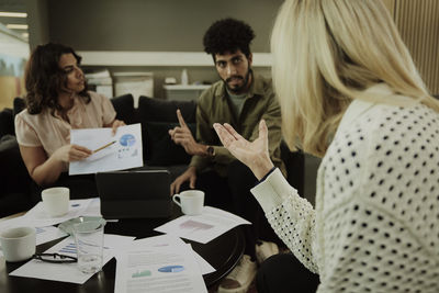 Group of business people analyzing charts during meeting in lobby