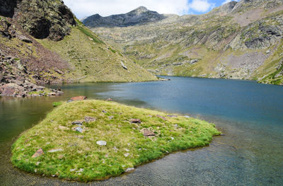 Scenic view of lake by mountain against sky