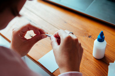 Close-up high angle view of woman holding thread on table