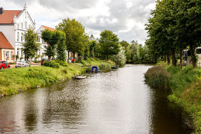 Scenic view of river amidst trees against sky