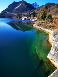 Scenic view of lake and mountains against blue sky