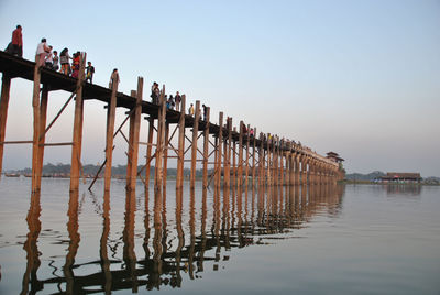 Tourists walking on pier over lake