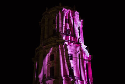 Low angle view of illuminated temple against black background