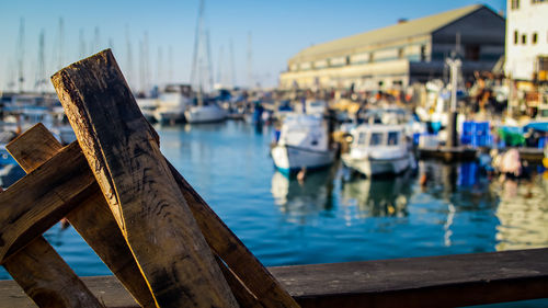 Boats moored in harbor at sea against sky