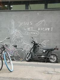 Bicycle parked on street against wall