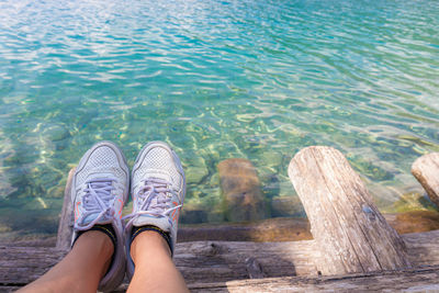 Low section of person relaxing on sea shore