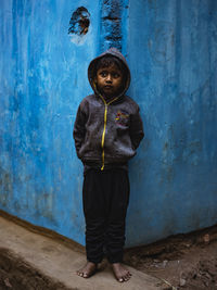 Full length of girl standing against blue wall