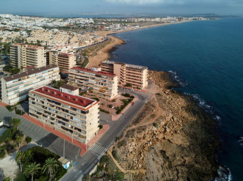 High angle view of buildings by sea against sky