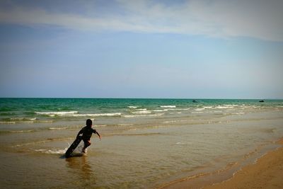 Man in sea against sky