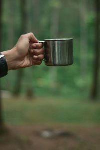 Midsection of man holding coffee cup