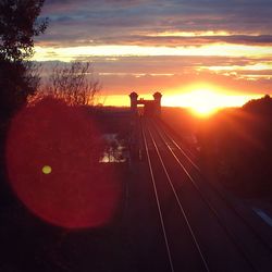 Railroad tracks against sky during sunset