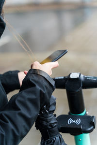 Midsection of woman using mobile phone outdoors