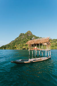 Boat in sea against clear blue sky