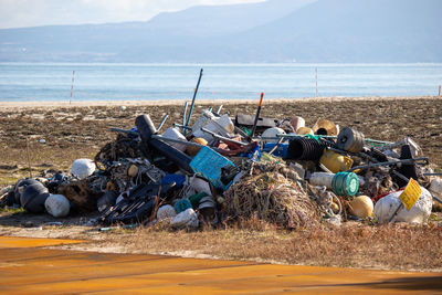 Garbage on beach by sea against sky