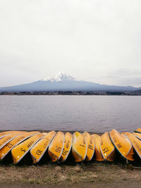 Scenic view of lake by snowcapped mountains against sky