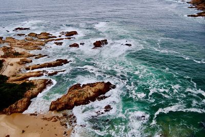 High angle view of rocks in sea - view from east head view point of the rocky knysna coastline 