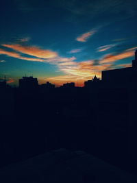 Silhouette city against sky during sunset