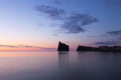 View of some percé village beachfront houses, its cliff and famous rock  during sunrise