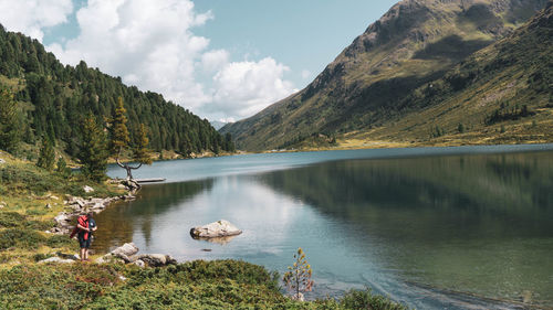 Scenic view of lake by mountains against sky