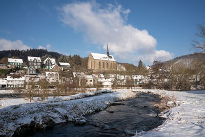 Buildings in city against sky during winter