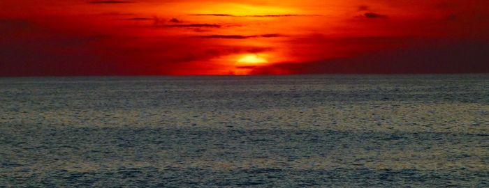 Scenic view of sea against romantic sky at sunset