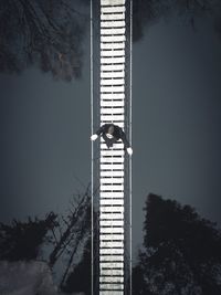 Low angle view of person standing by building against sky
