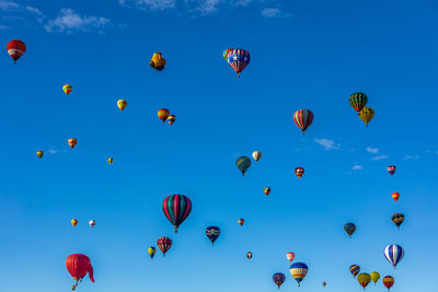 Low angle view of hot air balloons against blue sky