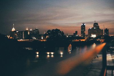 Illuminated cityscape against sky at night