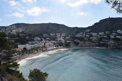 Scenic view of sea by town against sky