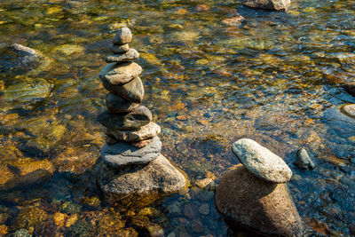High angle view of stone stack on rock in lake