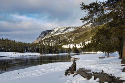 Scenic view of frozen lake by snowcapped mountains against sky