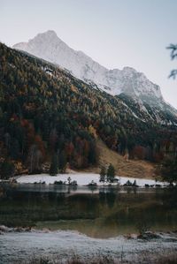 Scenic view of lake by mountains against sky