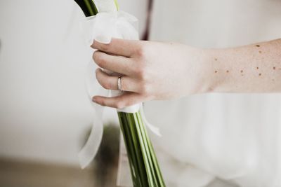 Cropped hand of bride holding bouquet