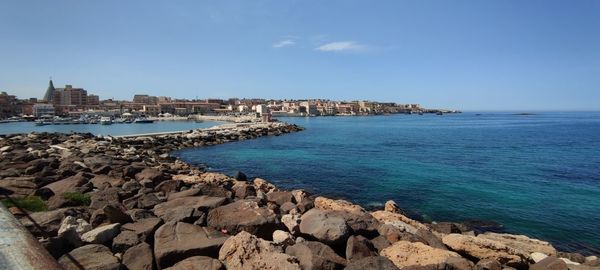 Panoramic view of sea and buildings against sky