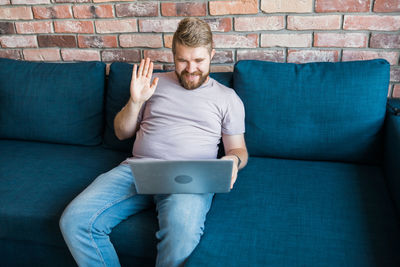 Boy using laptop while sitting on sofa at home