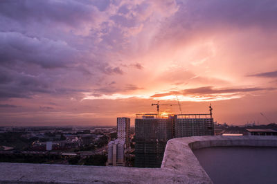 View of cityscape against cloudy sky during sunset