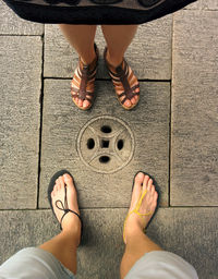 Low section of friends standing on footpath