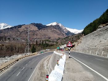 View of vehicles on road against clear sky