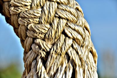 Close-up of rope tied to wooden post against sky