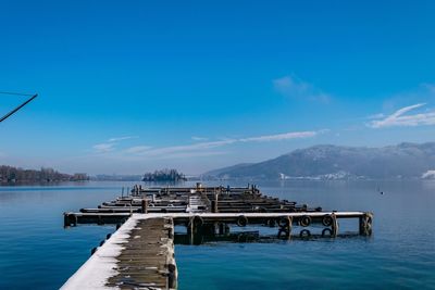 Pier on sea against blue sky