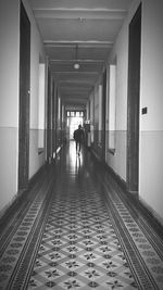 Rear view of people walking in corridor of building