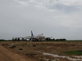 Abandoned airplane on field against sky