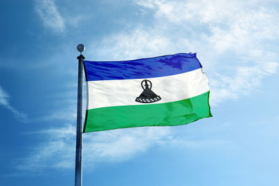 Low angle view of flag against blue sky